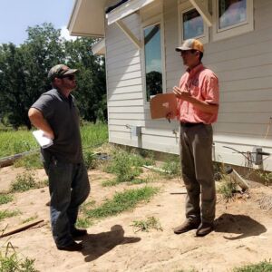 Longhorn Solar talking to new home builder about solar panel installation in front of house